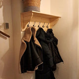 Le support mural à 2 crochets yessential.fr Nismo Black peut contenir des manteaux grâce à ses crochets élégants. Sur l'étagère au-dessus se trouve un panier tressé, le tout accentué par un éclairage intérieur chaleureux.