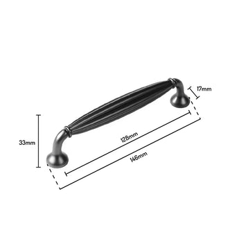 L'Alvaro Anthracite de yessential.fr est une poignée noire de style classique avec nervures décoratives, d'une longueur de 146 mm, un espacement des trous de 128 mm, une hauteur de 33 mm et une largeur de 17 mm - idéale pour mettre à niveau vos poignées d'armoire en zinc.