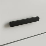 Un gros plan de l'Arriero Black Deluxe, une poignée rectangulaire arrondie noir mat de yessential.fr, fixée à une façade de tiroir blanche et lisse - un exemple moderne de poignées élégantes.