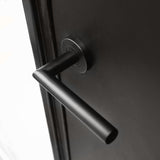 Un gros plan de la poignée de porte Lucio Black de yessential.fr, avec une poignée cylindrique noire mate montée horizontalement sur une porte sombre - un exemple élégant de poignées de porte noires modernes.