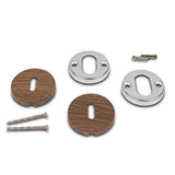 Quatre vis à métal, deux rosaces de poignée de porte en inox avec trous de serrure et deux "Rosettes Noyer" rondes de yessential.fr sont disposées sur un fond blanc.