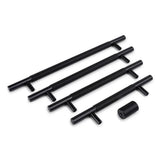 Quatre poignées Remo Black Deluxe de yessential.fr de différentes longueurs plus une petite poignée cylindrique avec moletage, le tout sur fond blanc. Les poutres latérales perpendiculaires donnent un aspect luxueux aux poignées de meubles.