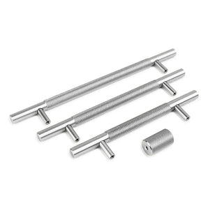 Trois clés à taraud Remo Stainless Steel Deluxe et une petite pièce cylindrique, toutes de yessential.fr, en acier inoxydable avec une texture de poignée raffinée, sont disposées sur un fond blanc.