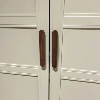Une paire de portes d'armoire Arriero Walnut de yessential.fr comporte des poignées verticales en bois rapprochées au centre, créant une illusion d'optique rappelant un hot-dog brun.