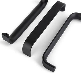 Trois poignées Leonardo Black Deluxe de yessential.fr sont présentées sur une surface blanche, chacune avec un design élégant et moderne avec des coins arrondis et des bords lisses sous différentes perspectives.