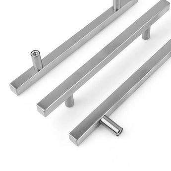 Trois poignées Marano en acier inoxydable de yessential.fr au design droit et minimaliste. Chaque poignée est représentée sous un angle différent sur fond blanc ; les vis sont visibles dans deux trous de montage.