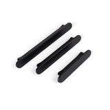 Trois poignées Arriero Black Deluxe de yessential.fr de différentes longueurs sont disposées en diagonale sur un fond blanc et ajoutent un style moderne à n'importe quelle armoire ou tiroir.