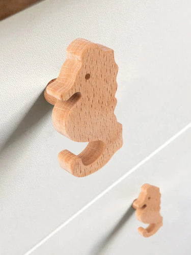 Gros plan de deux boutons de porte en bois Bambino Seahorse de yessential.fr sur un tiroir lumineux - idéal pour la chambre d'enfant - avec un bouton au point et l'autre légèrement flou en arrière-plan.