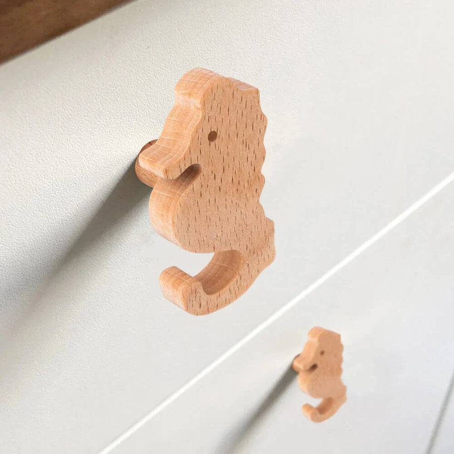 Gros plan de deux boutons de porte en bois Bambino Seahorse de yessential.fr sur un tiroir lumineux - idéal pour la chambre d'enfant - avec un bouton au point et l'autre légèrement flou en arrière-plan.