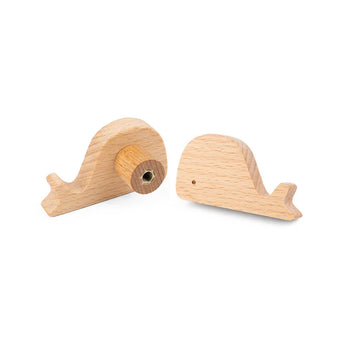 Bambino Willy de yessential.fr : deux petits boutons baleine en bois clair pour la chambre des enfants - l'un avec un cercle en métal, l'autre avec une silhouette de baleine.
