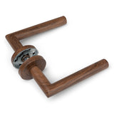 La poignée de porte Lucio Walnut de yessential.fr est présentée autoportante sur un fond blanc. La poignée rectangulaire en noyer avec une base en métal argenté offre un design minimaliste et moderne - idéale comme poignée de porte intérieure pour les intérieurs contemporains.