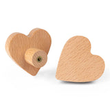 Deux boutons en bois Bambino Heart de yessential.fr sont présentés : l'un plat pour montrer la forme du cœur, l'autre vertical avec la fixation à vis visible - parfait pour ajouter une touche douce à la chambre de bébé.
