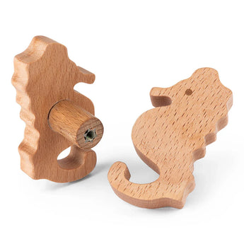 Les boutons de tiroir Bambino Seahorse de yessential.fr sont des boutons de meubles en bois avec une finition lisse et un grain de bois visible, idéaux pour une chambre d'enfant. Montrés sous différents angles pour souligner leur forme et leur fixation par vis.