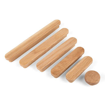 Cinq chevilles en bois de yessential.fr, dont la poignée en chêne Arriero, sont alignées sur fond blanc. Le grain du bois visible accentue quatre chevilles allongées et un disque rond.
