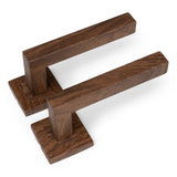 Deux poignées de porte Domaso Walnut de yessential.fr avec une base carrée et un design angulaire élégant sont placées côte à côte sur un fond blanc - parfaites pour une porte intérieure élégante.