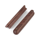 Deux porte-couteaux Arriero Walnut de yessential.fr, présentés face de haut en bas, mettent en valeur la finition en noyer lisse et les fermoirs métalliques intégrés à une extrémité.