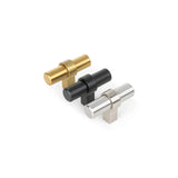 Trois boutons d'armoire cylindriques de yessential.fr, dont le bouton noir Arturo, sont alignés sur un fond blanc. Chaque bouton est disponible en or, noir mat et argent et s'intègre dans un design de cuisine moderne en forme de T.