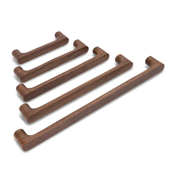 Cinq poignées en noyer Salgado de yessential.fr sont disposées en diagonale par taille sur une surface blanche. Ils présentent tous un design simple et moderne avec des coins arrondis, qui soulignent le style minimaliste de la marque.