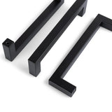 Trois poignées d'armoire Vasco Black de yessential.fr sont placées en diagonale sur un fond blanc. Chaque poignée présente un design moderne et minimaliste avec des lignes épurées et des angles vifs.