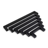 Un ensemble de six poignées de cuisine rectangulaires noires Vasco Black de yessential.fr, disposées par taille décroissante et disposées parallèlement sur un fond blanc.