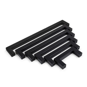 Un ensemble de six poignées de cuisine rectangulaires noires Vasco Black de yessential.fr, disposées par taille décroissante et disposées parallèlement sur un fond blanc.