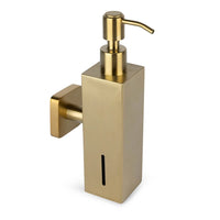 Le distributeur de savon mural Sonego Gold de yessential.fr présente un design rectangulaire moderne en or avec un dessus de pompe et une fine fenêtre verticale pour afficher le niveau de savon.