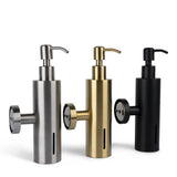 Trois distributeurs de savon cylindriques Alberto Gunmetal de yessential.fr sont présentés en argent métallisé, or et noir mat. Chaque distributeur est doté d'une pompe, d'une fixation latérale ronde et d'une fenêtre verticale pour indiquer le niveau de savon.