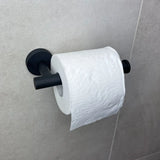 L'ensemble de toilettes Cosimo Black de yessential.fr comprend un rouleau de papier toilette sur un support mural noir mat, représenté sur un carrelage de salle de bain gris clair. Le papier toilette au relief subtil ajoute de l'élégance à vos accessoires de salle de bain.