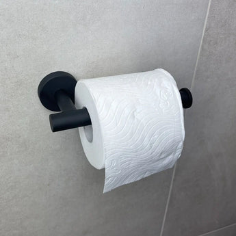 Un rouleau de papier toilette blanc sur l'ensemble de WC noir Lorenzo Black de yessential.fr est monté sur un carrelage gris clair et ajoute une touche élégante à vos accessoires de salle de bain.