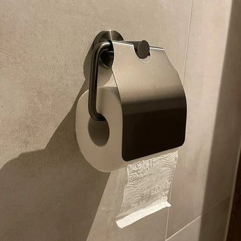 L'ensemble de toilettes Sandro Gunmetal de yessential.fr comprend un rouleau de papier toilette sur un support mural avec couvercle en métal, du papier sur le dessus et enroulable depuis le mur - un accessoire de toilette élégant en bronze à canon idéal pour la salle de bain moderne.