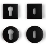 Quatre rosaces noires de yessential.fr sont présentées : deux carrées et deux rondes. Chaque forme comprend un trou de serrure traditionnel et une rosace cylindrique avec une fente ovale verticale.