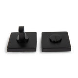 L'ensemble Domaso Black de yessential.fr se compose de deux poignées de porte carrées noires : une avec une poignée tournante et une avec une fente pour une pièce de monnaie ou un tournevis, représentées sur fond blanc.