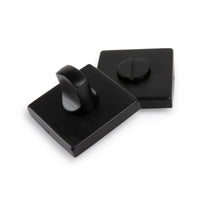 Deux serrures de WC Vano Black de yessential.fr - avec un bouton rotatif et une fente pour une clé plate - ont une finition noire mate élégante, toutes deux présentées sur un fond blanc.