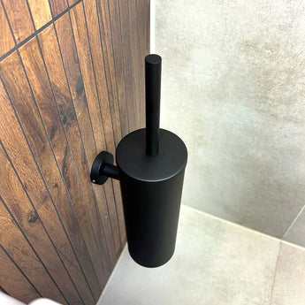 L'ensemble de toilettes Mano Black de yessential.fr est monté sur un mur à motif bois à côté de carrelage beige, ce qui donne un look élégant au coin de la salle de bain.
