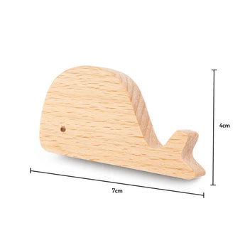 Le Bambino Willy de yessential.fr est un petit bouton de baleine en bois, parfait comme bouton de meuble en bois pour chambre d'enfant, mesurant 7 cm de long et 4 cm de haut, représenté sur un fond blanc avec des lignes dimensionnelles.