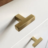 Gros plan de deux boutons Vigio Gold de yessential.fr sur un boîtier blanc, avec un éclairage doux mettant en valeur le design élégant et moderne en or mat.