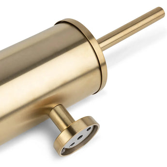 Un gros plan de l'ensemble WC Nando Gold de yessential.fr, comprenant un porte-brosse WC en métal doré avec poignée assortie dans un design cylindrique moderne et une base ronde - idéal pour des accessoires de toilettes ou de salle de bain élégants.